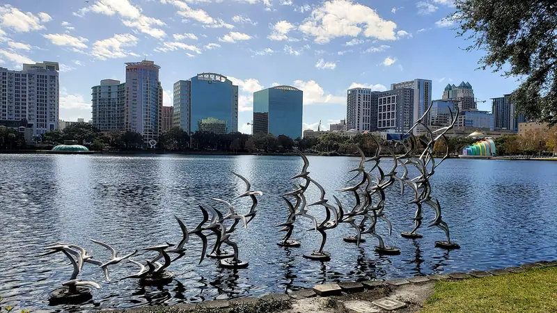 Lake Eola Park in downtown Orlando on a sunny day, with the skyline across the water